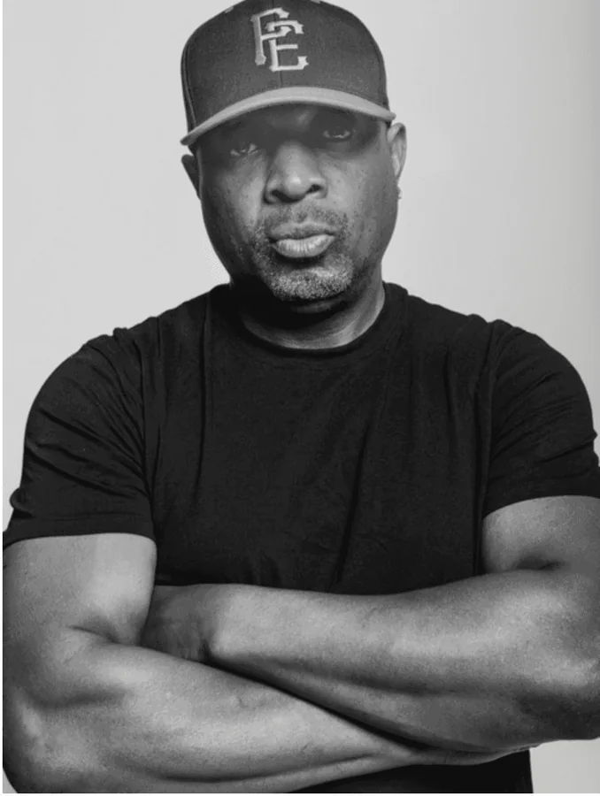 Chuck D of Public Enemy, black and white portrait, arms crossed