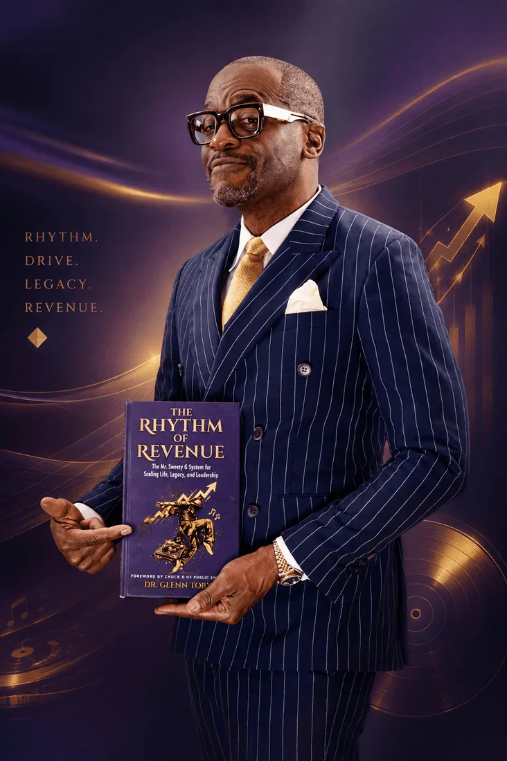 Dr. Glenn Toby in a navy pinstripe suit holding The Rhythm of Revenue
